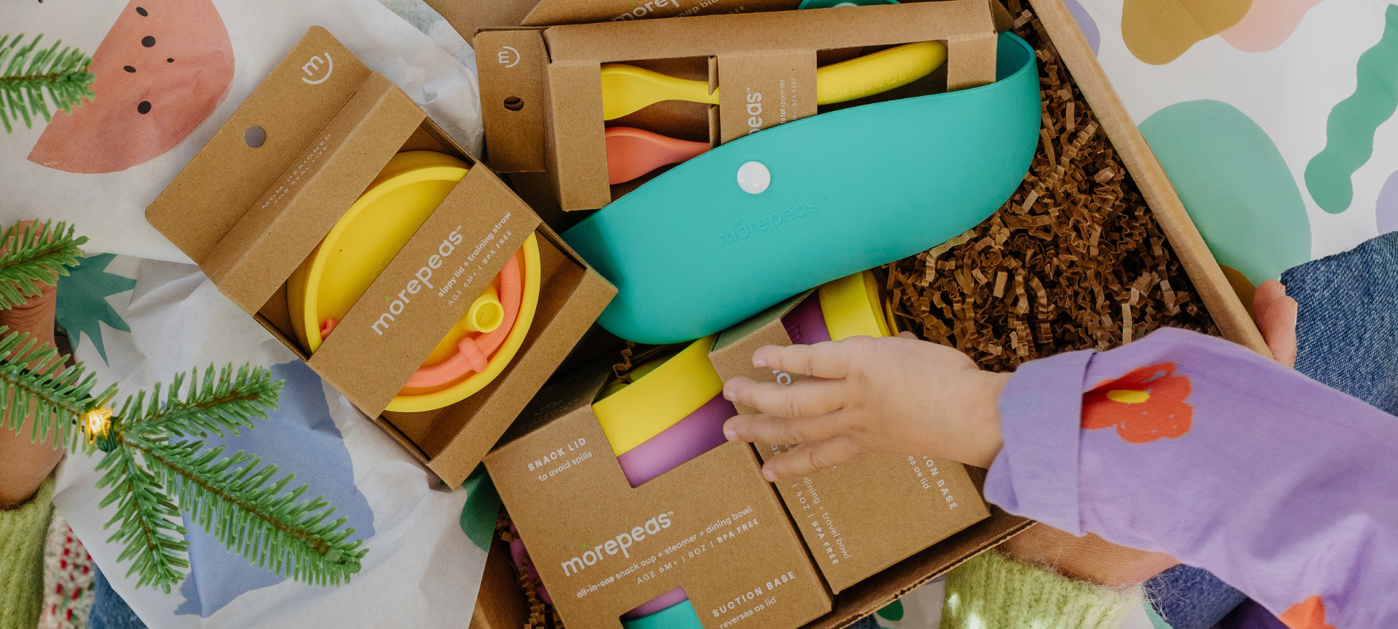 Overhead shot of child's hand opening a morepeas gift bundle