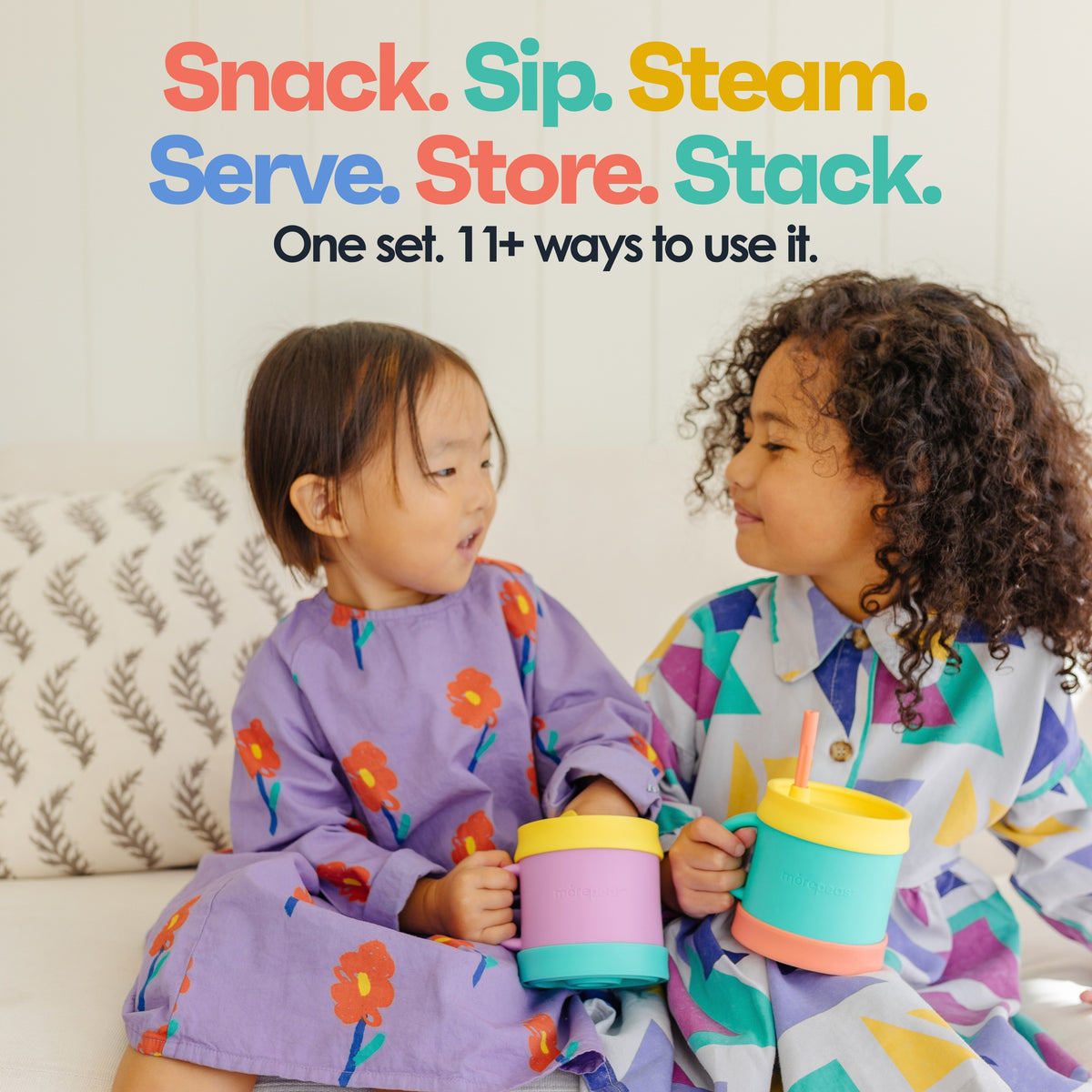 Two toddlers holding Snack Stack cups with sippy and snack lids