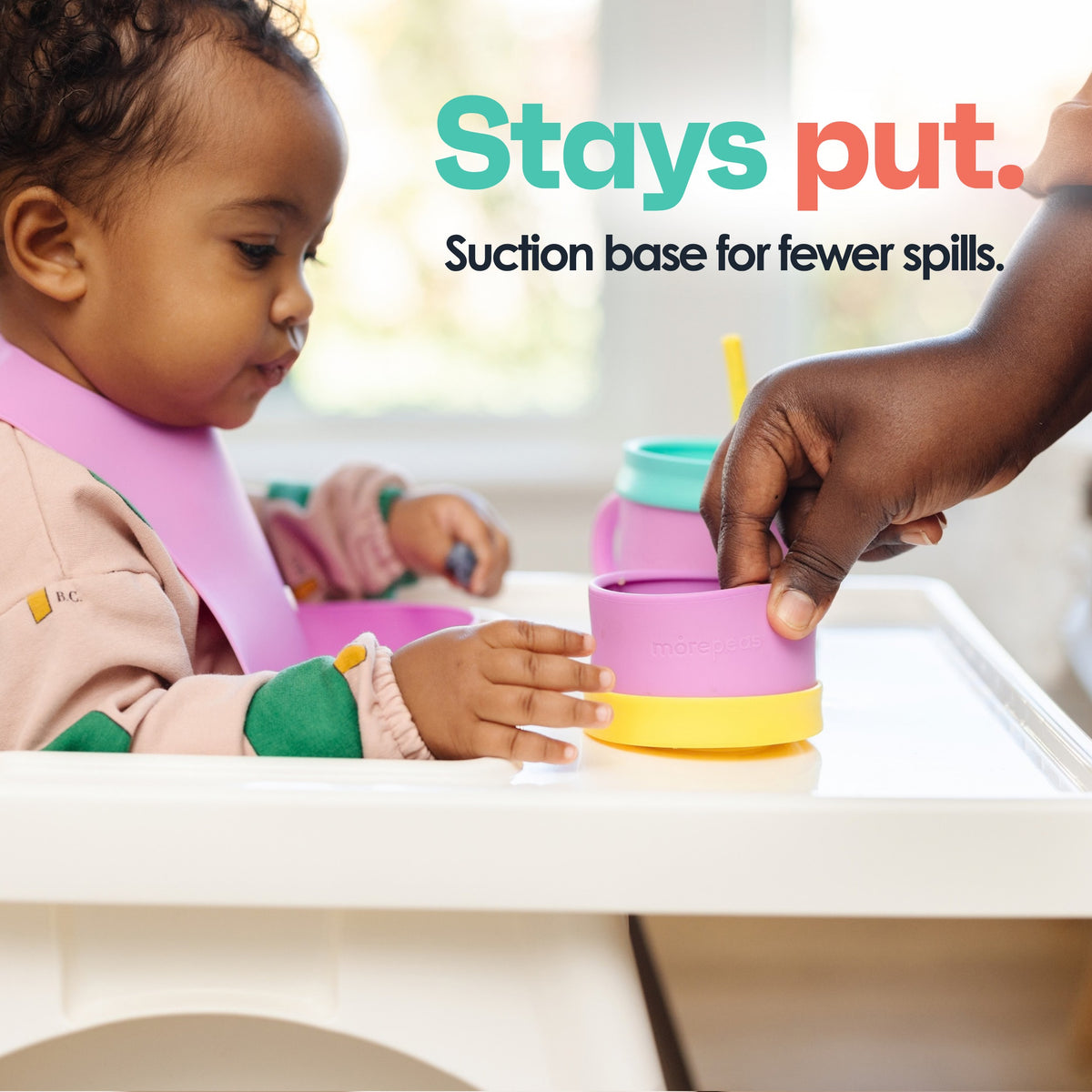Toddler reaching for a Snack Stack bowl suctioned to a high chair tray