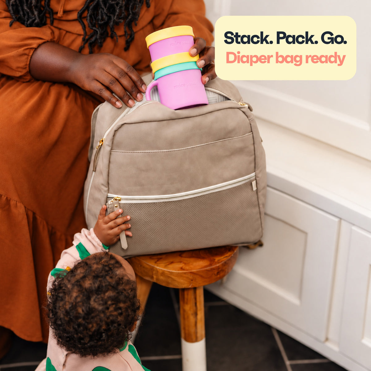 Mom packing a stacked Snack Stack set into a diaper bag